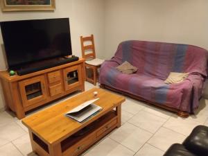a living room with a couch and a flat screen tv at chambre dans une maison in Chassagnes