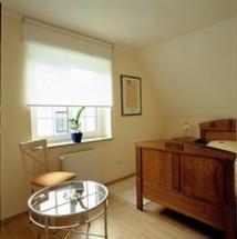 uma sala de estar com uma mesa de vidro e uma janela em Hotel Veltrup em Laer