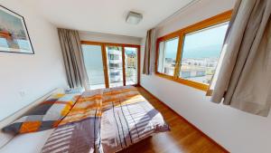 a bedroom with a bed and a large window at Bijou in Mitten von Naters in Naters