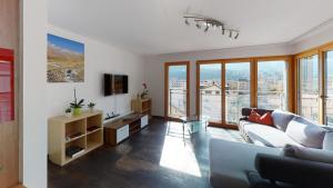 a living room with a couch and a tv at Bijou in Mitten von Naters in Naters