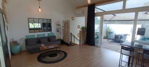 a living room with a couch and a table at O'sun avec jacuzzi privatif in Frontignan