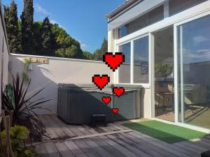 a patio with red hearts on the side of a house at O'sun avec jacuzzi privatif in Frontignan