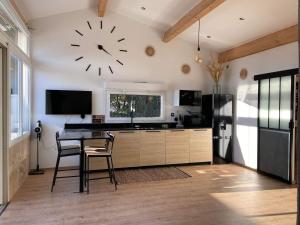 a kitchen with a table and a clock on the wall at O'sun avec jacuzzi privatif in Frontignan