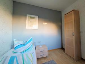 a bedroom with a bed and a dresser and a door at Ferienwohnung Borken in Bad Salzungen +5 photos
