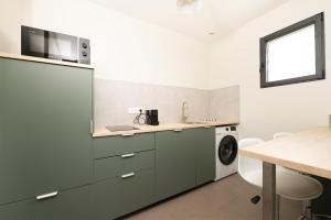 a kitchen with a sink and a washing machine at Maison Épure - maison mitoyenne avec jardin in Colomiers
