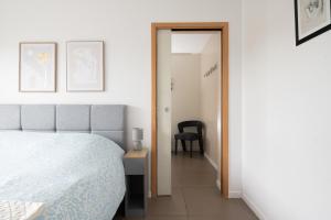 a bedroom with a bed and a table and a chair at Maison Épure - maison mitoyenne avec jardin in Colomiers