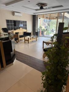 a lobby with a living room with a table and chairs at Hotel Golden in Lahore