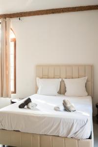 a bedroom with a large white bed with towels on it at Domaine de la batelle in Arles