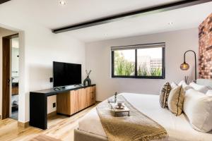 a living room with a bed and a television at ULIV Roma Norte in Mexico City +21 photos