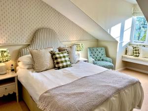 een slaapkamer met een groot bed en een stoel bij The Fox Inn in Ansty