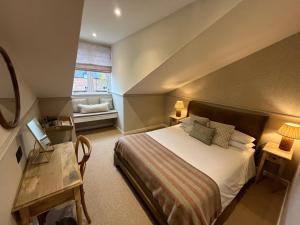 een slaapkamer met een groot bed en een raam bij The Fox Inn in Ansty +15 foto's