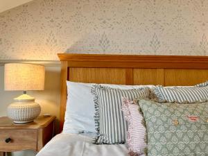 een bed met kussens en een lamp op een tafel bij The Fox Inn in Ansty