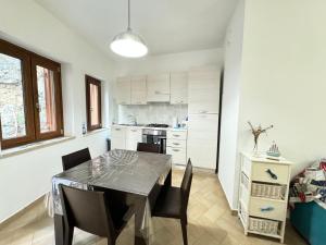 a kitchen and dining room with a table and chairs at Mare Apartment 4 in Scalea