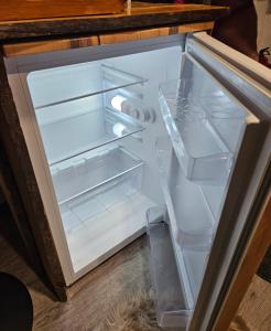 an empty refrigerator with its door open on the floor at Nordic Nest Living. in Rovaniemi