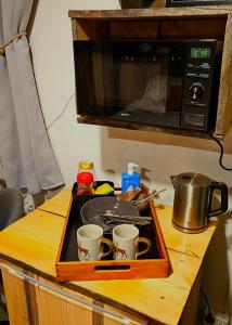 a tray with cups on a counter with a microwave at Nordic Nest Living. in Rovaniemi