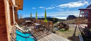a deck with chairs and tables on a house at Chalet Die Berghexn in Klippitztorl