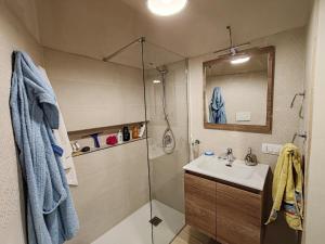 un bagno con doccia, lavandino e specchio di Appartamento alla Immacolata Noto Centro Storico a Noto Altre 20 foto