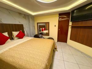 a bedroom with a large bed with red pillows at Hostal Mayra Breña in Lima