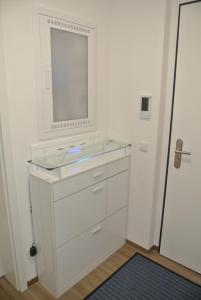 a white bathroom with a sink and a mirror at Ferienwohnung Meer-Zeit in Lubmin +15 photos