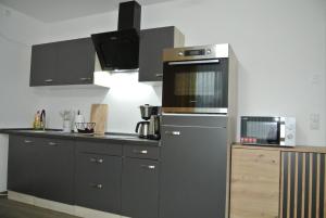 a kitchen with black cabinets and a microwave at Ferienwohnung Meer-Zeit in Lubmin