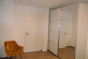 a closet with a chair and a glass door at Ferienwohnung Meer-Zeit in Lubmin