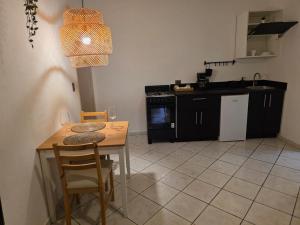 a kitchen with a table and chairs and a kitchen with black cabinets at Serenity Dominicus in La Laguna