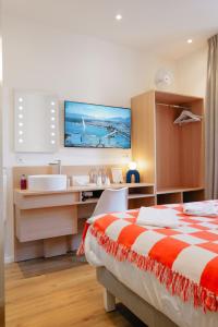 a bedroom with a bed and a sink and a tub at Rhodania Boutique Hôtel in Geneva