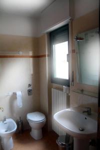 La salle de bains est pourvue de toilettes blanches et d'un lavabo. dans l'établissement Euro Inn B&B, à Milan