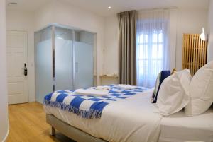 a bedroom with a large bed with blue and white sheets at Rhodania Boutique Hôtel in Geneva +37 photos