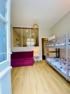 een slaapkamer met een stapelbed en een bank bij Le Gîte Du Parc avec parking vieux port et plage au calme in La Rochelle