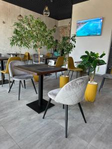 een eetkamer met een tafel, stoelen en planten bij Avto Spa in Chmelnytsky
