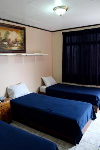 a room with two beds and a window at Hotel Costa del Sol in Puerto Limón