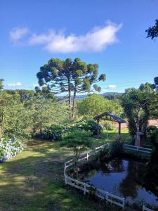a garden with a pond and a gazebo at Cabana da Serra in Riozinho