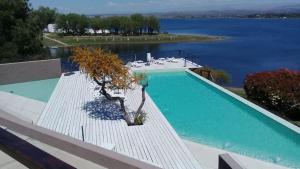 a swimming pool with a tree sitting on a white deck at PUEBLO CHICO - casas de lago in Villa Ciudad de América +29 photos