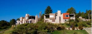a house sitting on top of a hill with trees at PUEBLO CHICO - casas de lago in Villa Ciudad de América