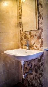 lavabo blanco en el baño con espejo en Guest House Meridi, en Preseltsi