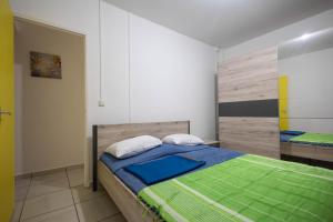 a bedroom with a bed with blue and green sheets at Kanelle in Baie-Mahault