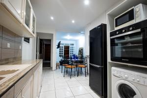a kitchen with a washer and dryer and a table at Kanelle in Baie-Mahault
