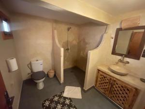 a small bathroom with a toilet and a sink at Hotel Soleil Blue in Boumalne Dades