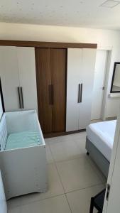 a bedroom with a bed and a chest of cabinets at Ap Alto São Bento in Itapema
