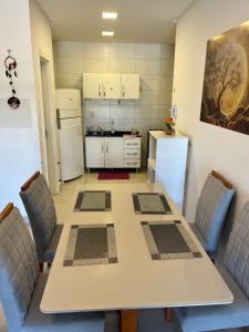 a kitchen with a table and chairs and a refrigerator at Ap Alto São Bento in Itapema +18 photos