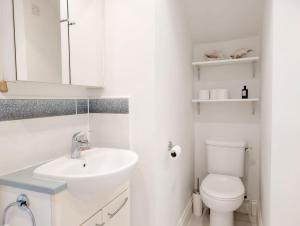 a white bathroom with a sink and a toilet at 1a Tower Street - Emsworth in Emsworth +8 photos
