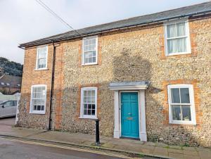 a brick building with a blue door on a street at 1a Tower Street - Emsworth in Emsworth