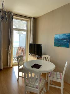 a living room with a table and chairs and a television at Fürstenhof Sassnitz in Sassnitz