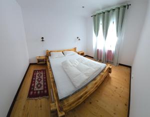 a bed in a room with a wooden floor at The Froggies in Gura Negri