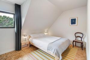 a white bedroom with a bed and a window at Chalet da Azenhas in Colares +13 photos