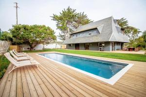 a swimming pool on a wooden deck next to a house at Chalet da Azenhas in Colares