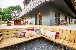 a wooden bench with pillows on a wooden deck at Chalet da Azenhas in Colares
