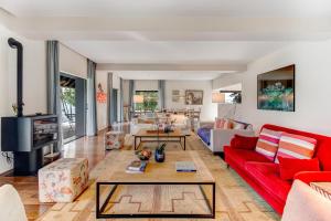 a living room with a red couch and a table at Chalet da Azenhas in Colares