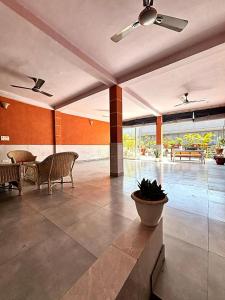 a lobby with a table and chairs and a ceiling fan at Ashu Villa in New Delhi